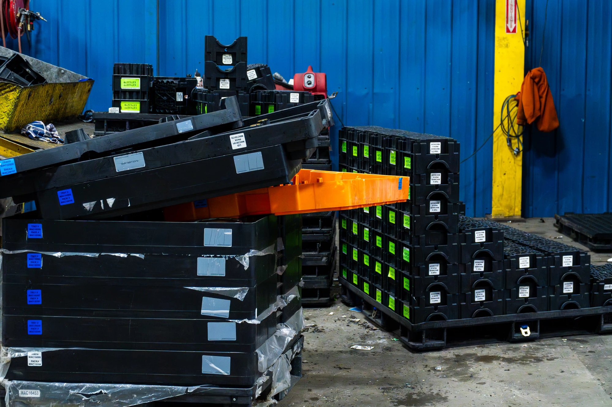 Mixed plastic dunnage and totes staged indoors for inspection and material identification. Mixed plastic dunnage and totes staged indoors for inspection and material identification.