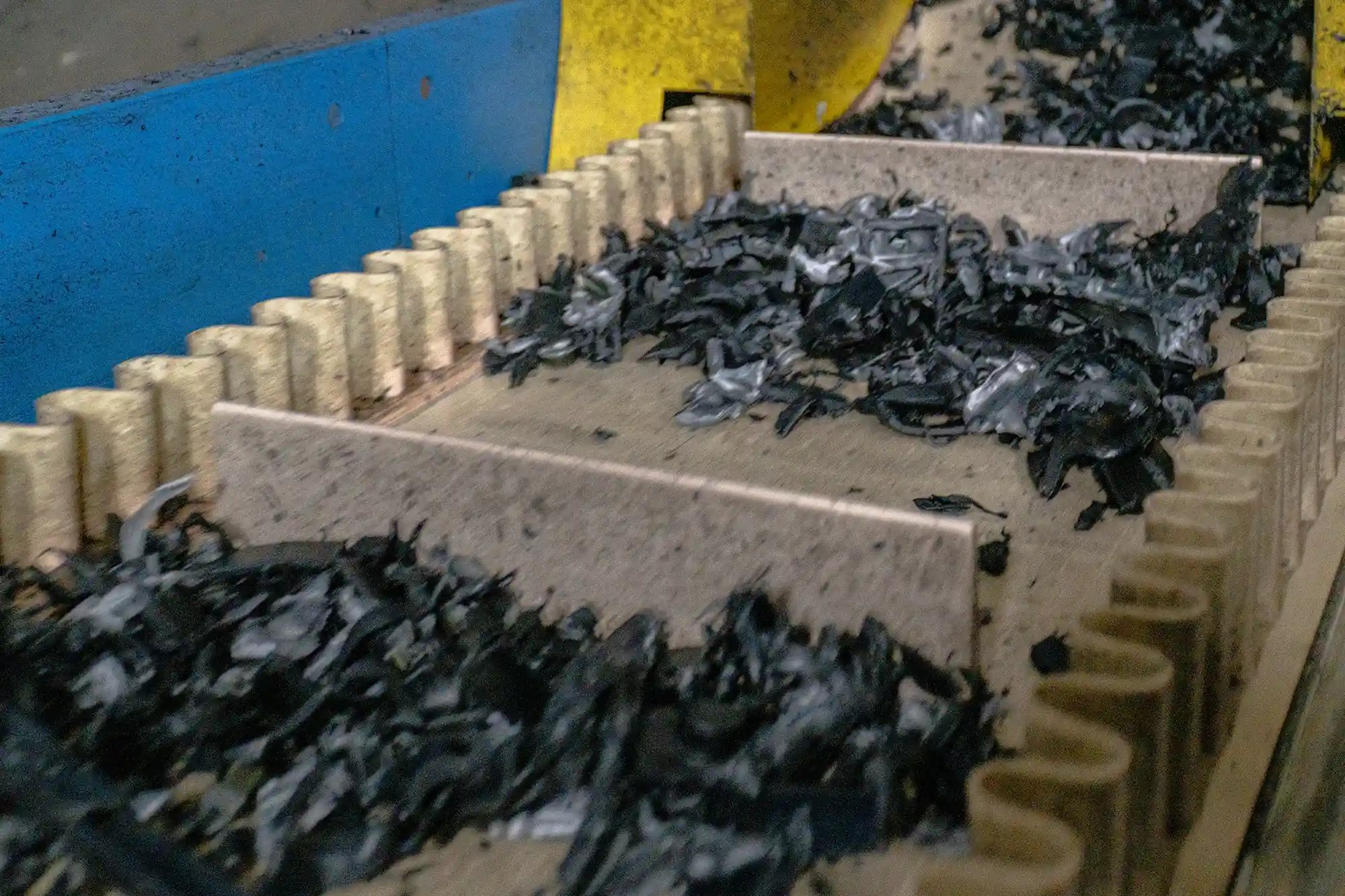 Conveyor sorting line moving shredded plastic pieces for washing and downstream processing. Conveyor sorting line moving shredded plastic pieces for washing and downstream processing.