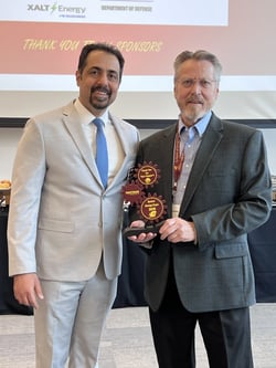 George Aultman and Dr. Ernur Karadogan stand together at CMU’s Senior Design Expo, holding a Vantage Plastics sponsor appreciation plaque.